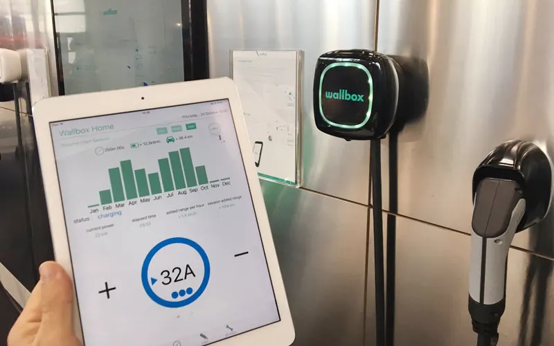 Carregador Wallbox Pulsar na parede e tablet com o consumo de energia